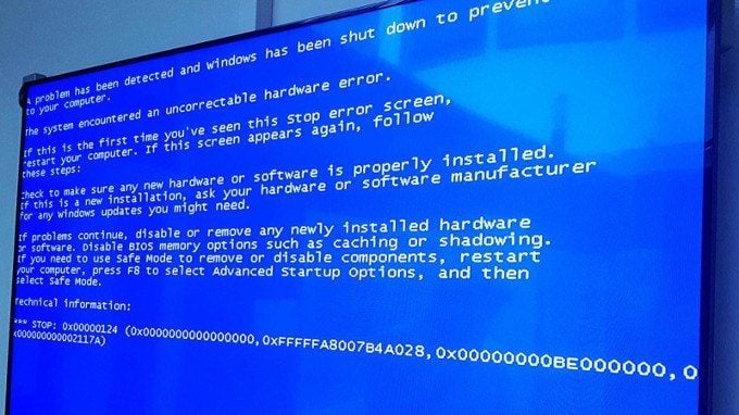 A computer screen displays the Windows blue screen of death error message, indicating a system crash with white text on a blue background detailing a hardware or software failure.